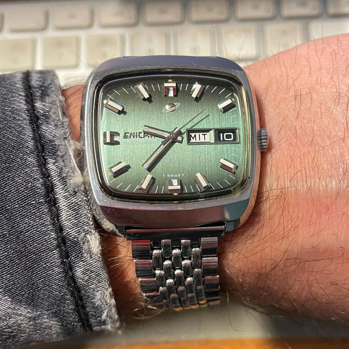 DDM 260 with a green sunburst dial and day-date in a TV-shaped steel case on a beads-of-rice bracelet, on the wrist