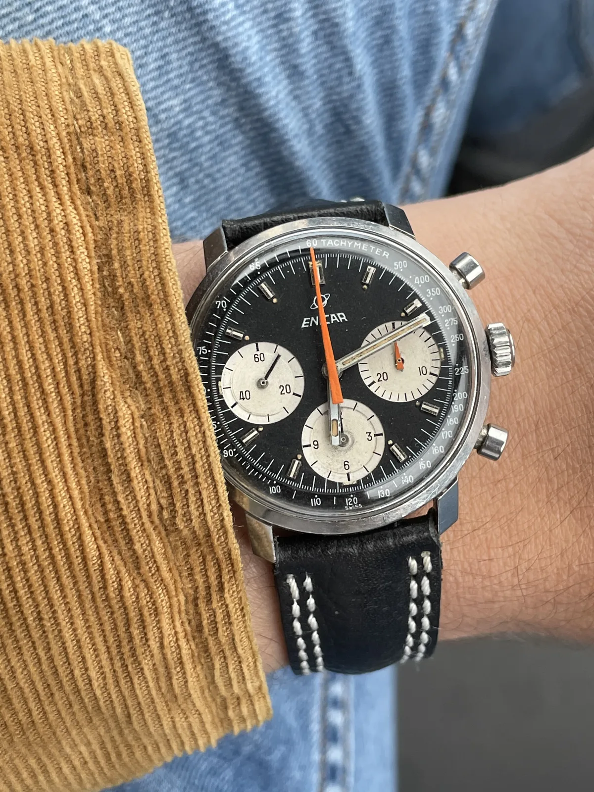 Garnix chronograph with a black dial, silver registers, no model name and an orange chronograph hand, on the wrist