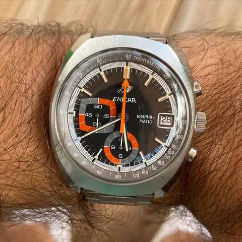 Grapho-Matic in a cushion case with a grey dial and orange registers on a steel bracelet, on the wrist