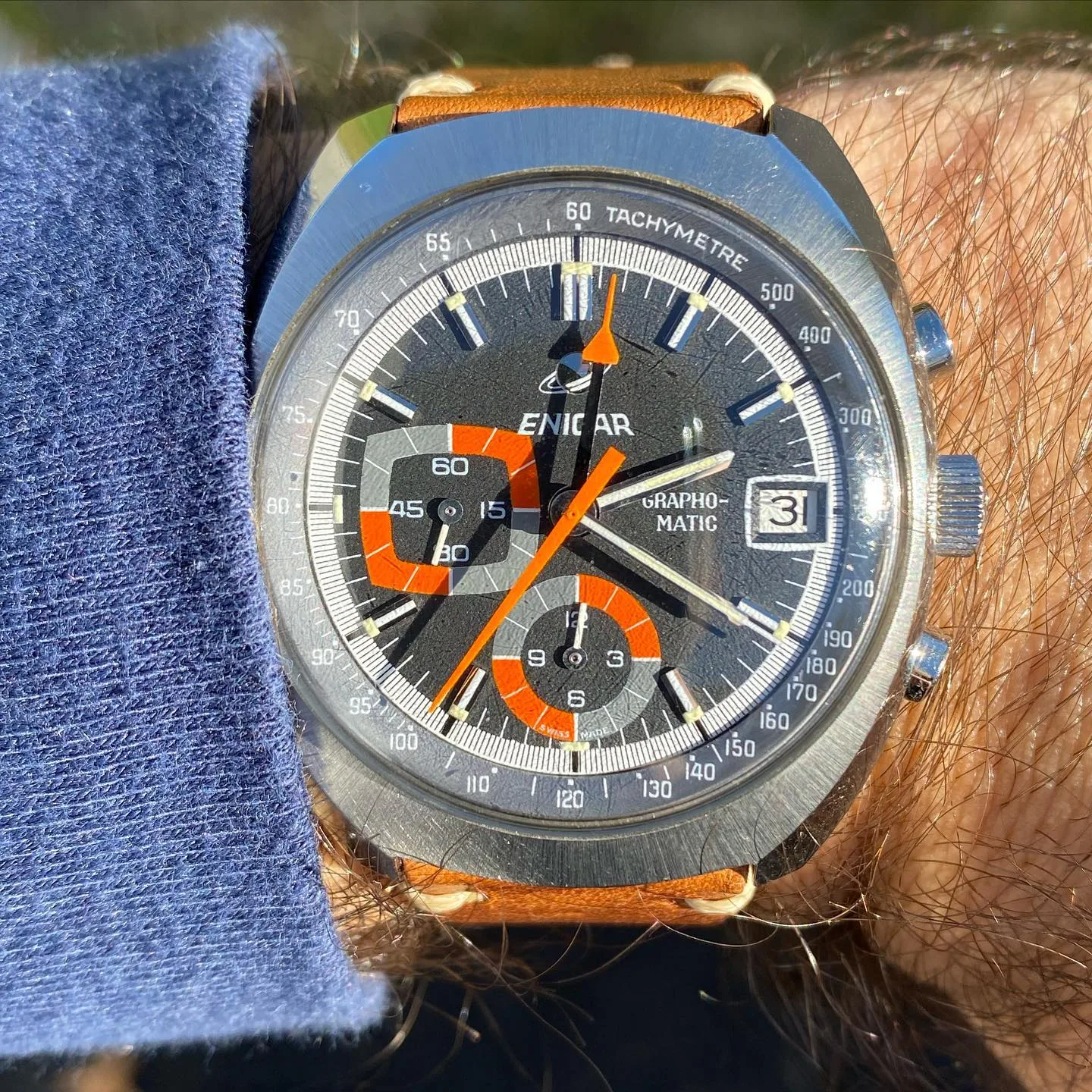 Grapho-Matic with a grey dial, orange chronograph hand and orange-framed registers on a tan strap, on the wrist