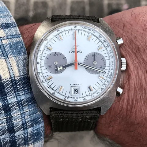 Lausanne chronograph with a white dial, grey registers and orange chronograph hand on an olive canvas strap, on the wrist