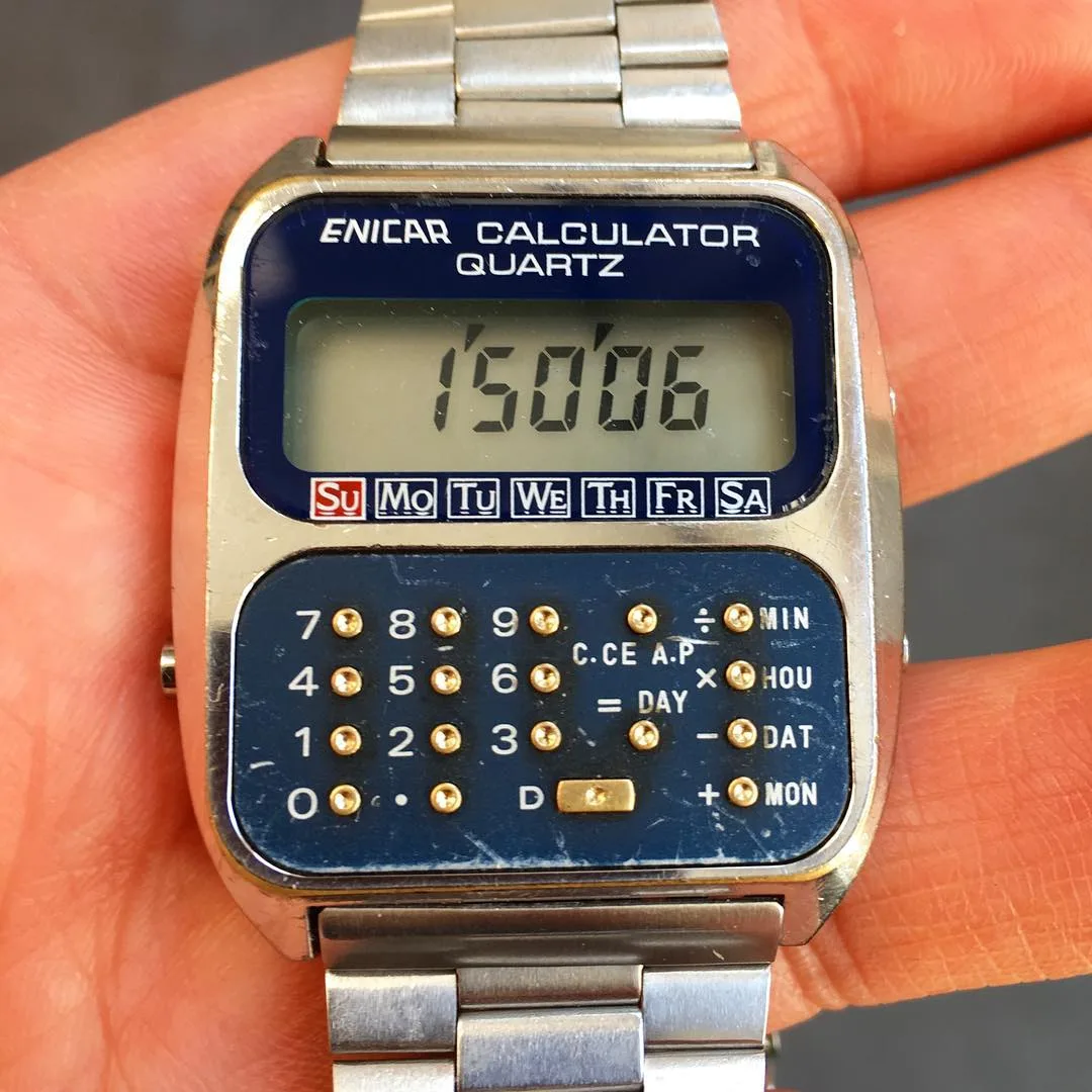 Calculator Quartz with an LCD and a blue calculator keypad on the dial, held in the hand