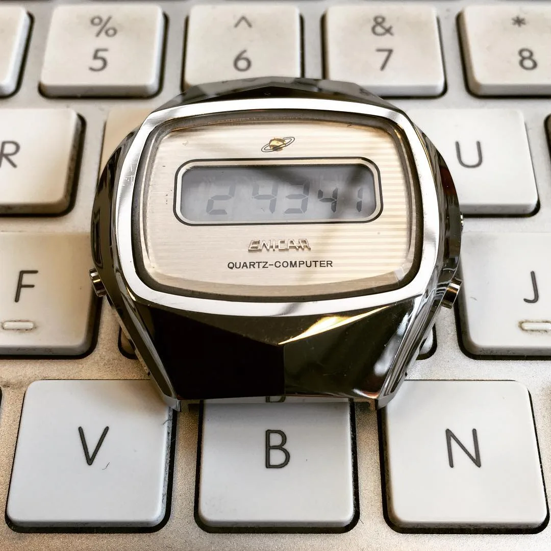Quartz-Computer LCD watch in a faceted steel case, on a keyboard
