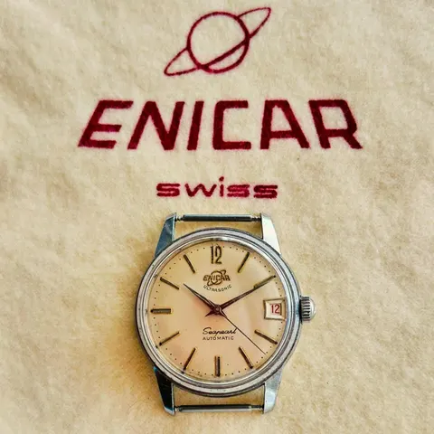 Seapearl automatic with a cream dial and red date, in front of an Enicar cloth