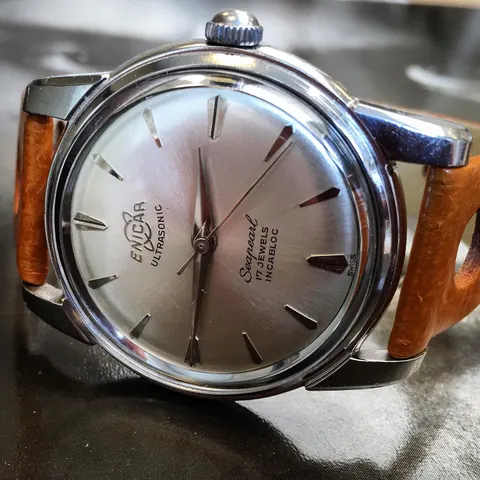 Seapearl with a silver dial and long baton markers on a brown strap