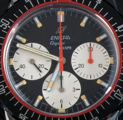Close-up of an Aqua Graph black dial with white registers and an orange-red minute-counter hand