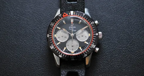 Aqua Graph with a black dial and grey registers, black 60-minute bezel and red ring, on a black perforated rally strap
