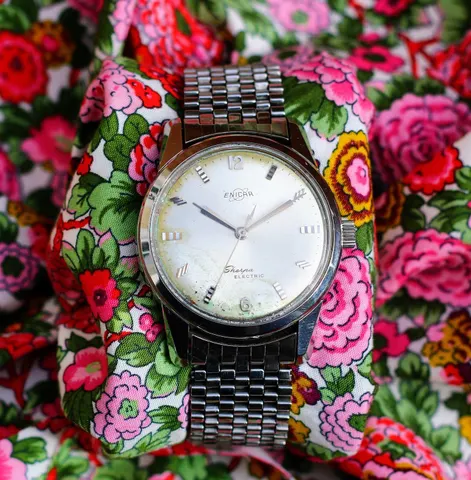 Steel Sherpa Electric with a silver dial on a steel bracelet, on flowered fabric