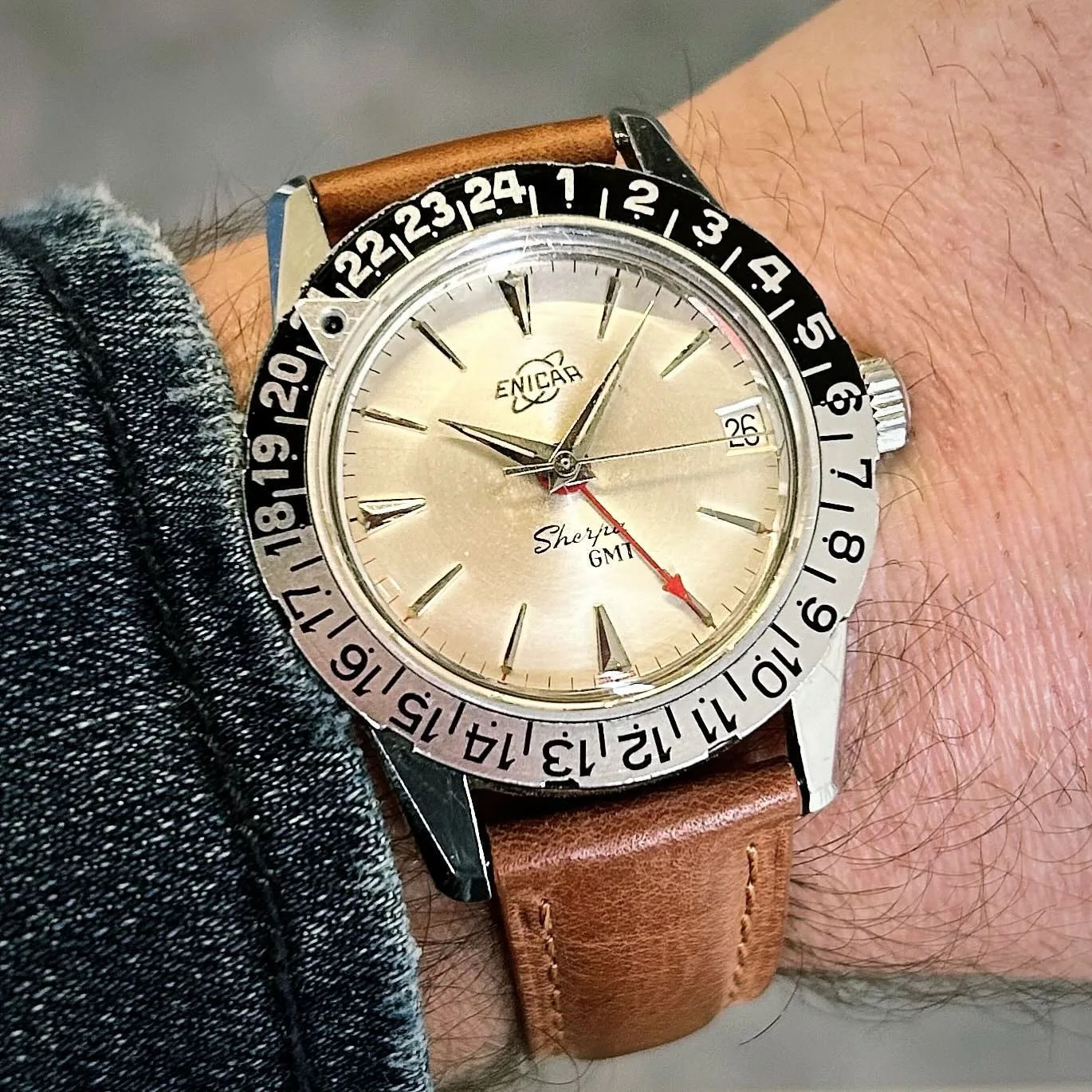 Sherpa GMT with a cream dial, red GMT hand and black and silver outer 24-hour bezel, on the wrist