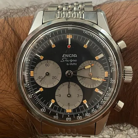 Close view of a Sherpa Graph with a black dial, grey registers and orange-tipped hands on a steel bracelet