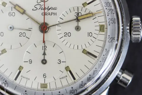 Close-up of the white Sherpa Graph dial at 3 o'clock showing the tachymetre scale starting at 300