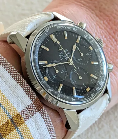 Sherpa Graph with a black dial and tachymeter scale on a white strap, on the wrist