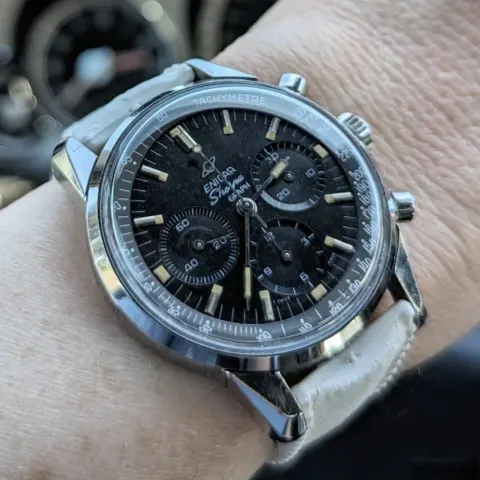 Sherpa Graph with a black dial and black subdials on a white strap, on the wrist