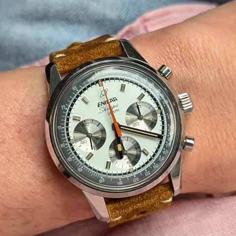 Sherpa Graph with a white dial, silver registers and orange triangle chronograph hand on a tan suede strap