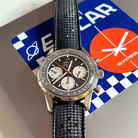 Sherpa Graph with a black dial and white registers on a black Tropic strap, in front of an Enicar display