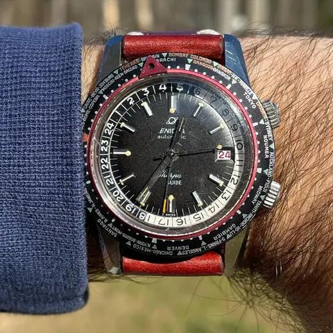 Sherpa Guide with a black dial, red date and world-city bezel on a red strap, on the wrist