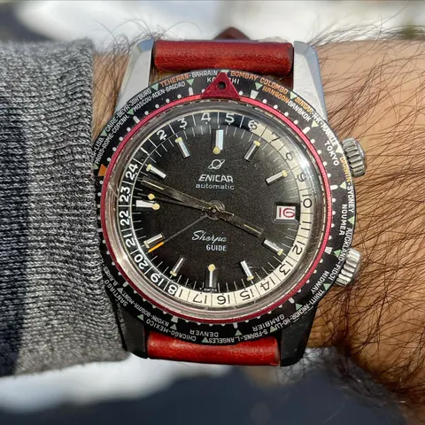 Sherpa Guide with a black dial and cream inner 24-hour bezel on a red strap, on the wrist