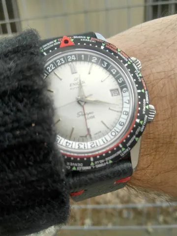 Sherpa Guide MkI with a white dial and world-city bezel on a black strap with red stitching, on the wrist