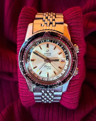 Sherpa Guide automatic with a silver dial, dark pointer and world-city outer bezel on a steel bracelet