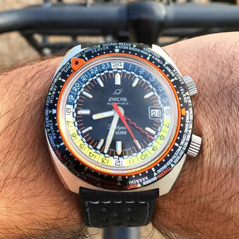 Sherpa Guide with a black dial, orange pointer and world-city bezel, on the wrist