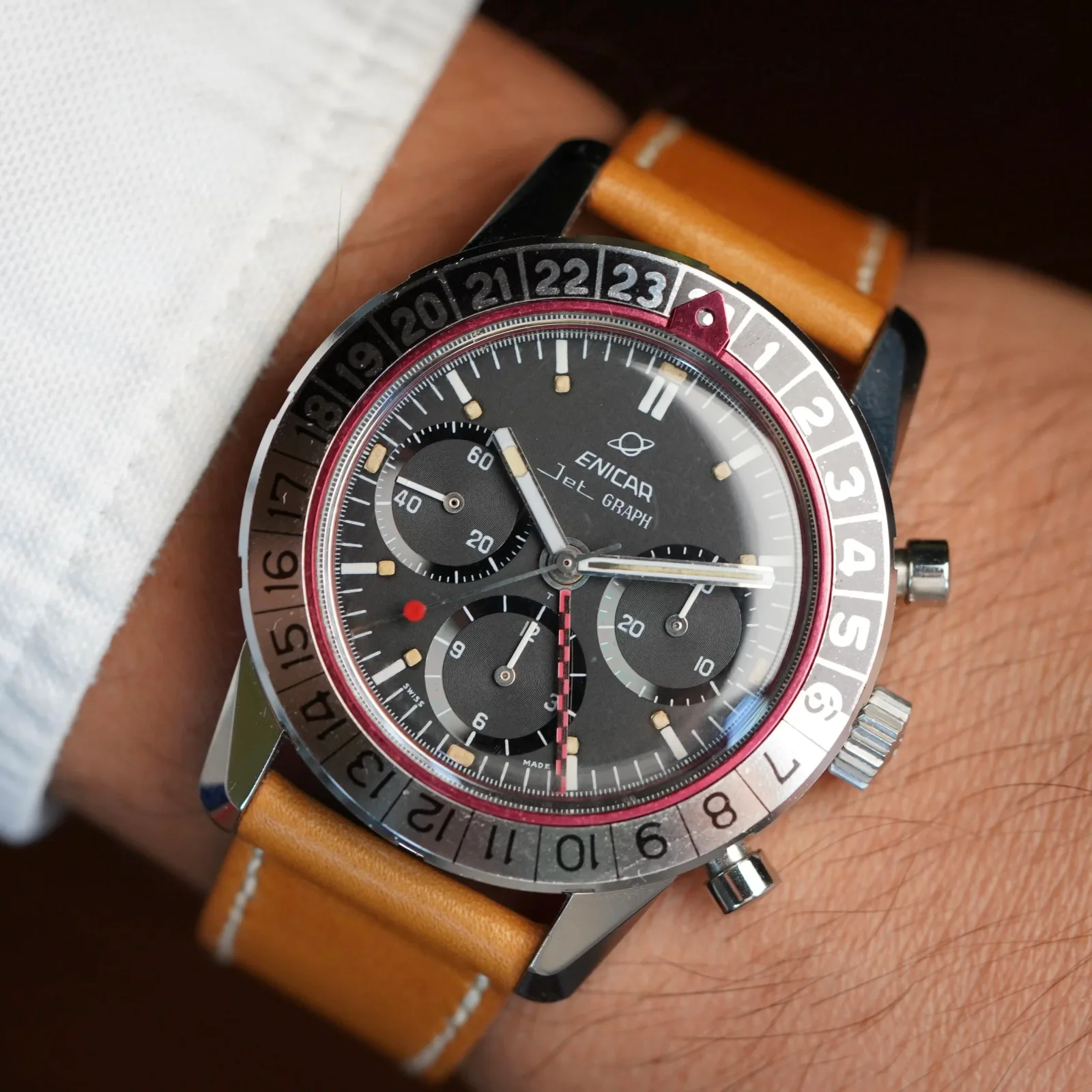 Jet Graph MkIII with an all-black dial, checkered GMT hand and 24-hour bezel on a tan strap