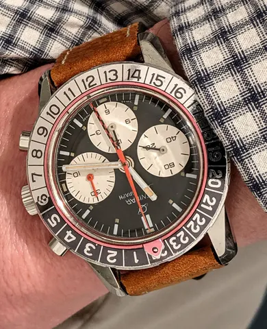 Jet Graph with a black dial, white registers and red counter hands on a brown suede strap