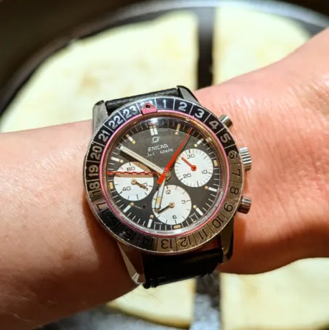 Jet Graph with a black dial, white registers, red minute-counter hand and checkered GMT hand, on the wrist