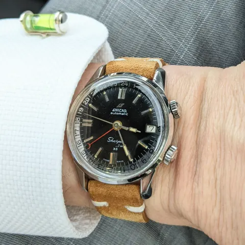 Sherpa Jet 33 with a black dial on a tan suede strap, on the wrist