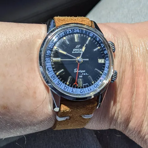 Sherpa Jet 33 with a black dial and blue and white 24-hour bezel on a tan suede strap