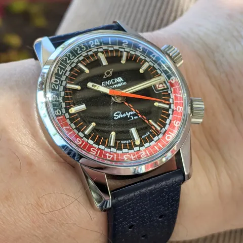 Sherpa Jet with a black dial, orange-tipped hand and red and blue inner bezel on a blue strap