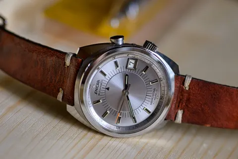 Enicar Memostar alarm watch with a silver dial and a date window, on a brown leather strap