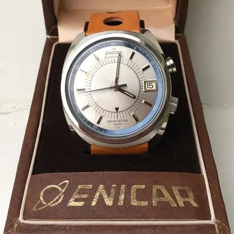 Enicar Memostar alarm watch with a silver and pale blue dial and a date window, in its Enicar box on a tan strap