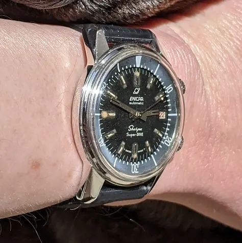 Sherpa Super-Dive with a black dial on a black strap, on the wrist