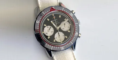 Super Graph MkIII with a black dial, silver registers, red pointer ring and grey 60-minute bezel, on a white strap