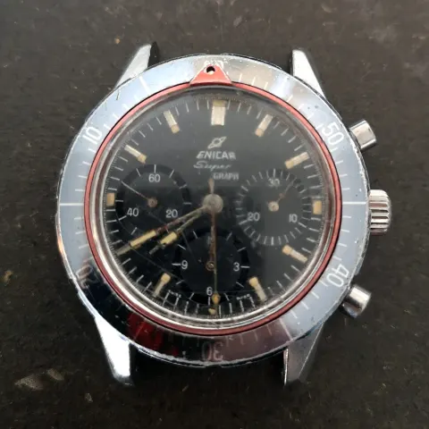 Super Graph head with an all-black dial, grey countdown bezel and red ring with a triangle pointer