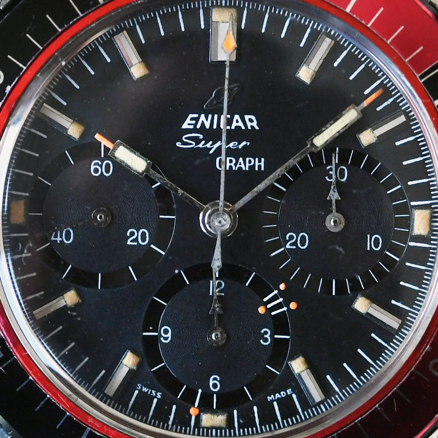 Close-up of the Super Graph "Simonet" black dial with black registers and orange marks on the hour counter