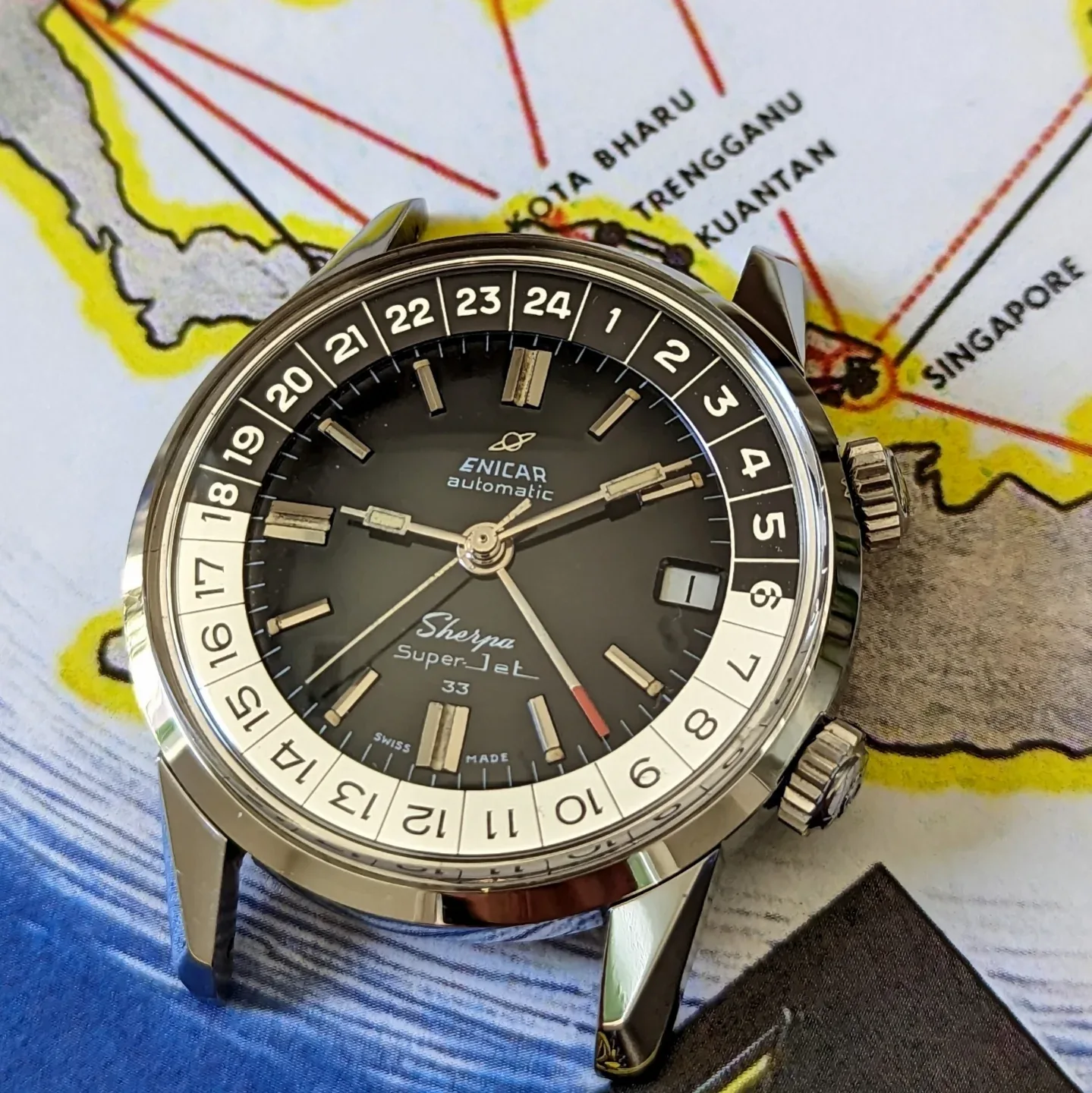 Sherpa Super-Jet 33 with a black dial, paddle hands and black and white 24-hour bezel, on a map of Malaysia and Singapore
