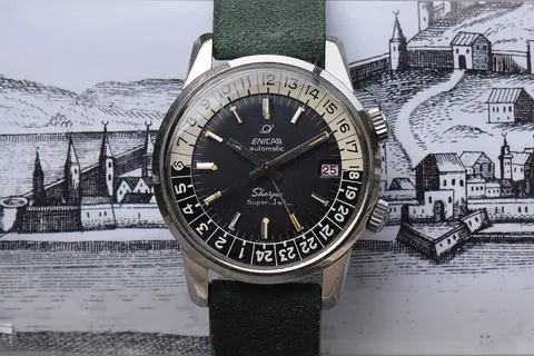 Sherpa Super-Jet with a black dial and cream and black 24-hour bezel on a green suede strap, over an old town engraving