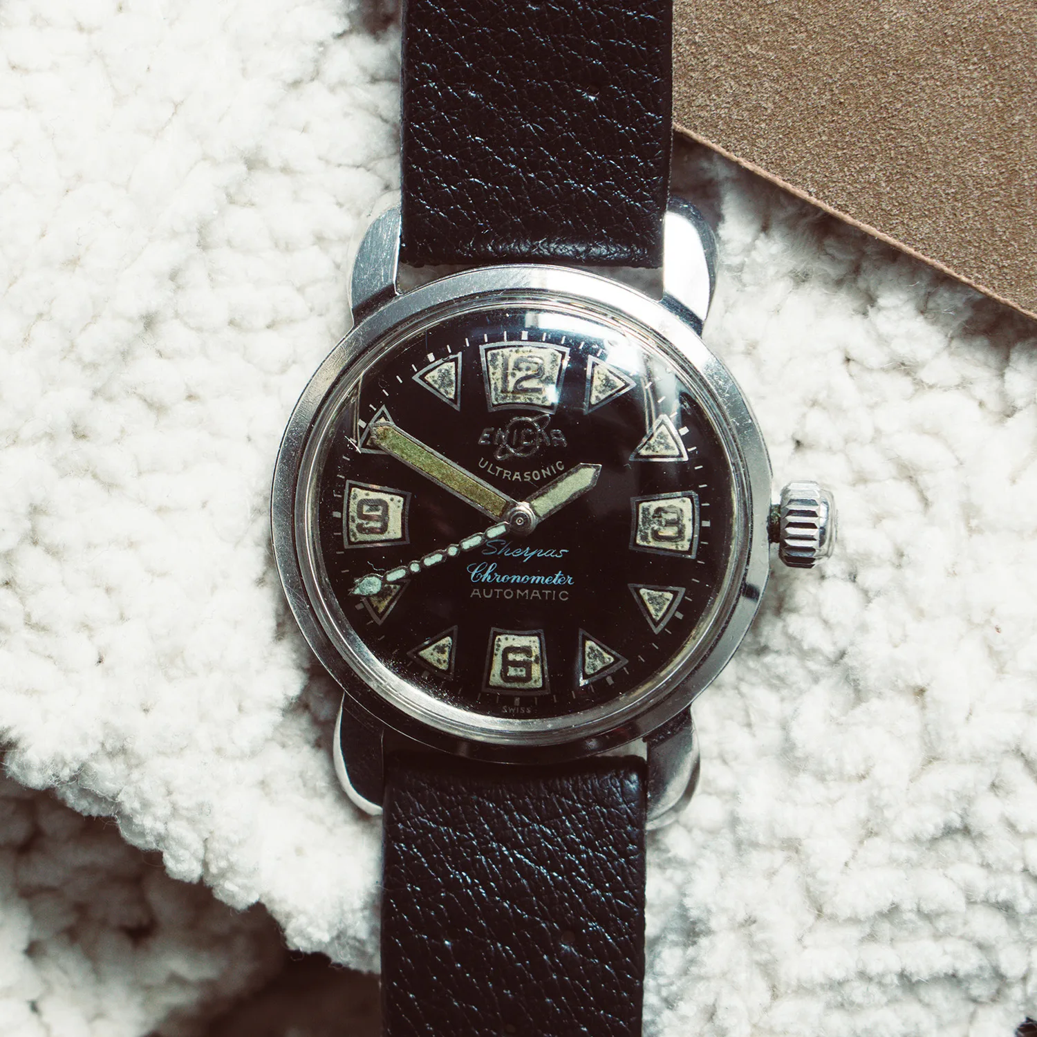 Ultrasonic Sherpas Chronometer with a black dial, triangle and Arabic markers on a black strap