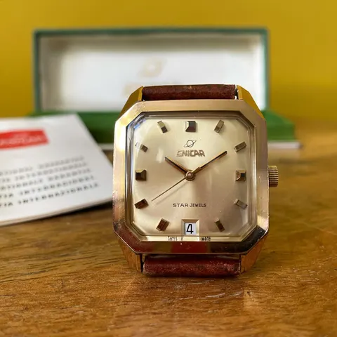 Gold-coloured square-case Star Jewels with a silver dial and date, with its box and papers