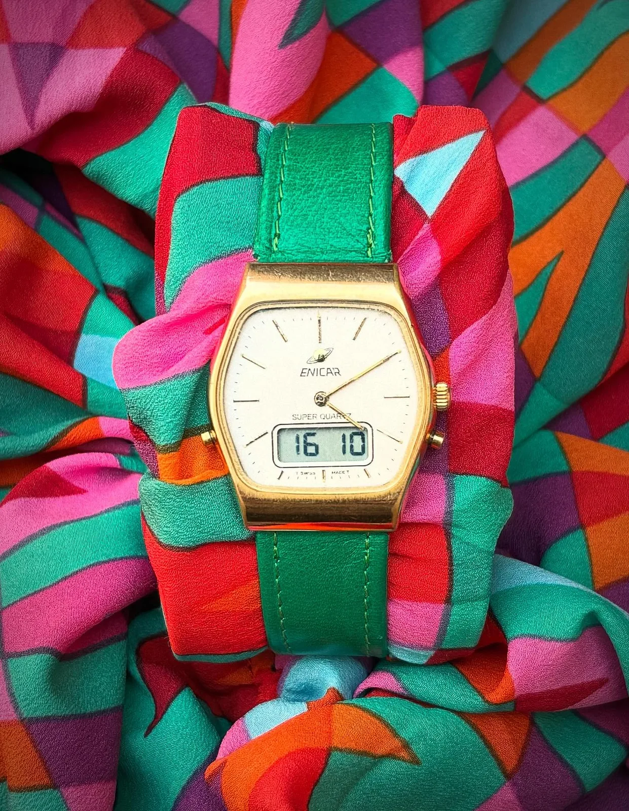 Gold-coloured Super Quartz with a cream dial, hands and an LCD window, in a shaped case on a green strap