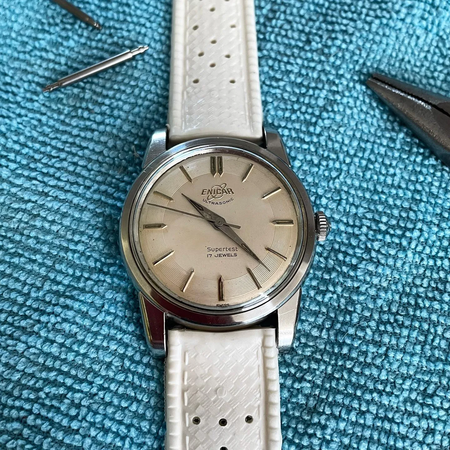 Supertest with a silver dial and arrow markers on a white perforated strap